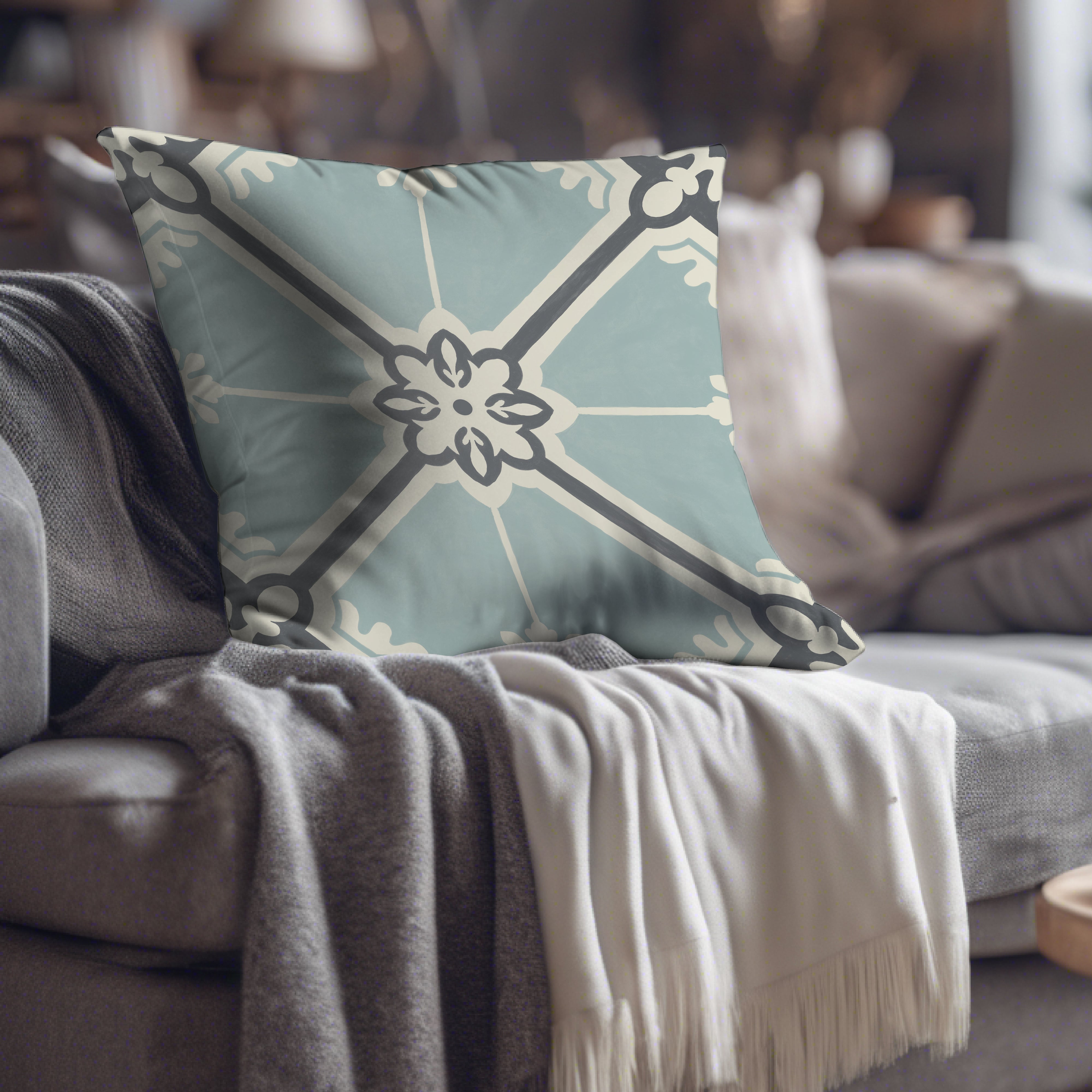 a blue and white pillow sitting on top of a couch