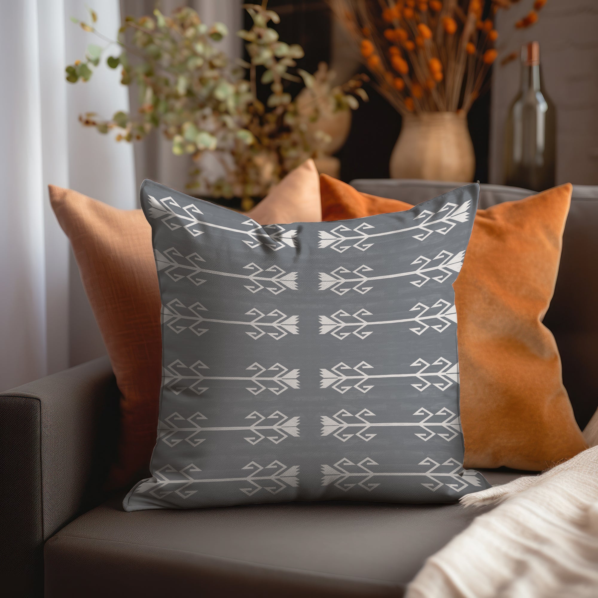 a gray and orange pillow sitting on top of a couch