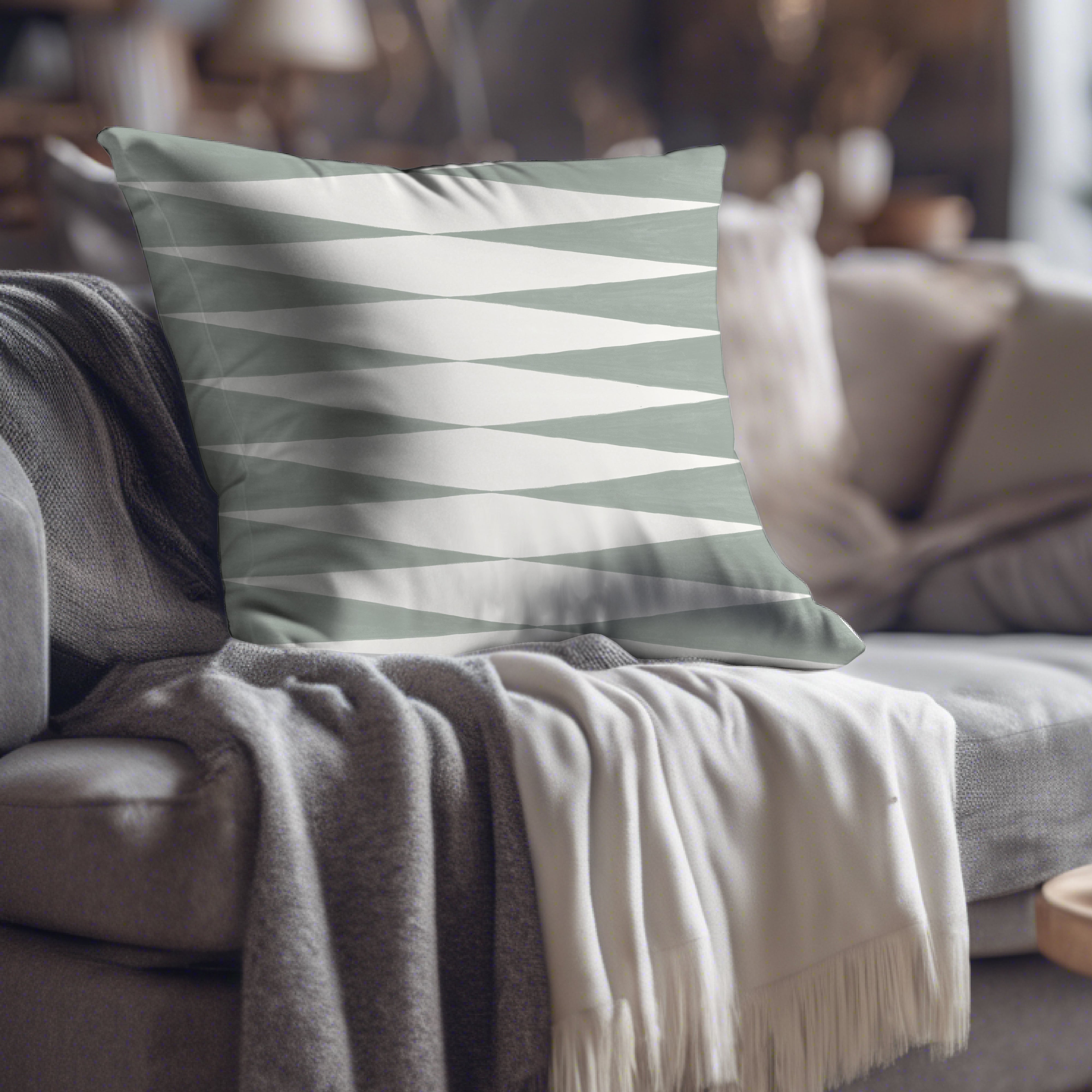 a gray and white pillow sitting on top of a couch