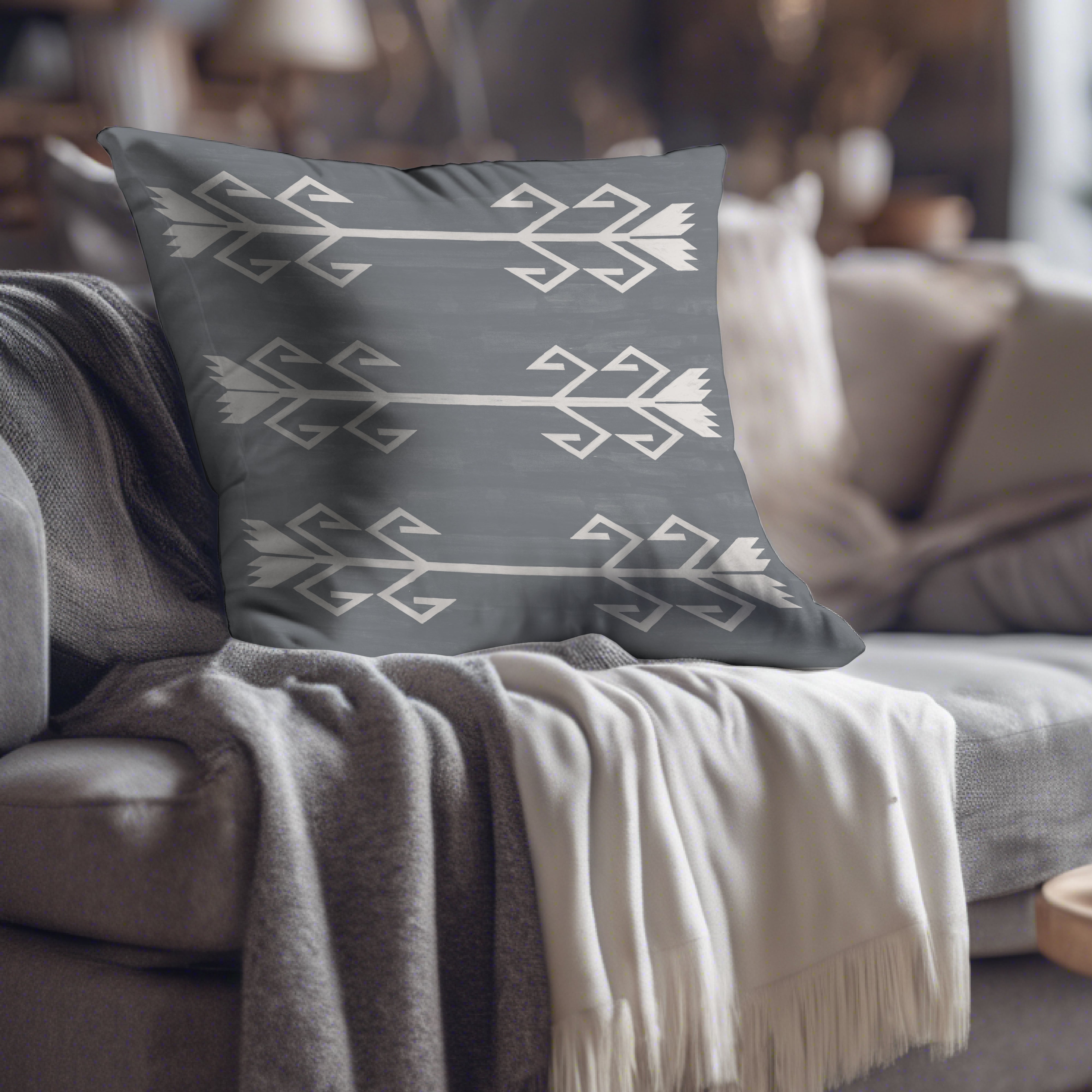 a gray and white pillow sitting on top of a couch