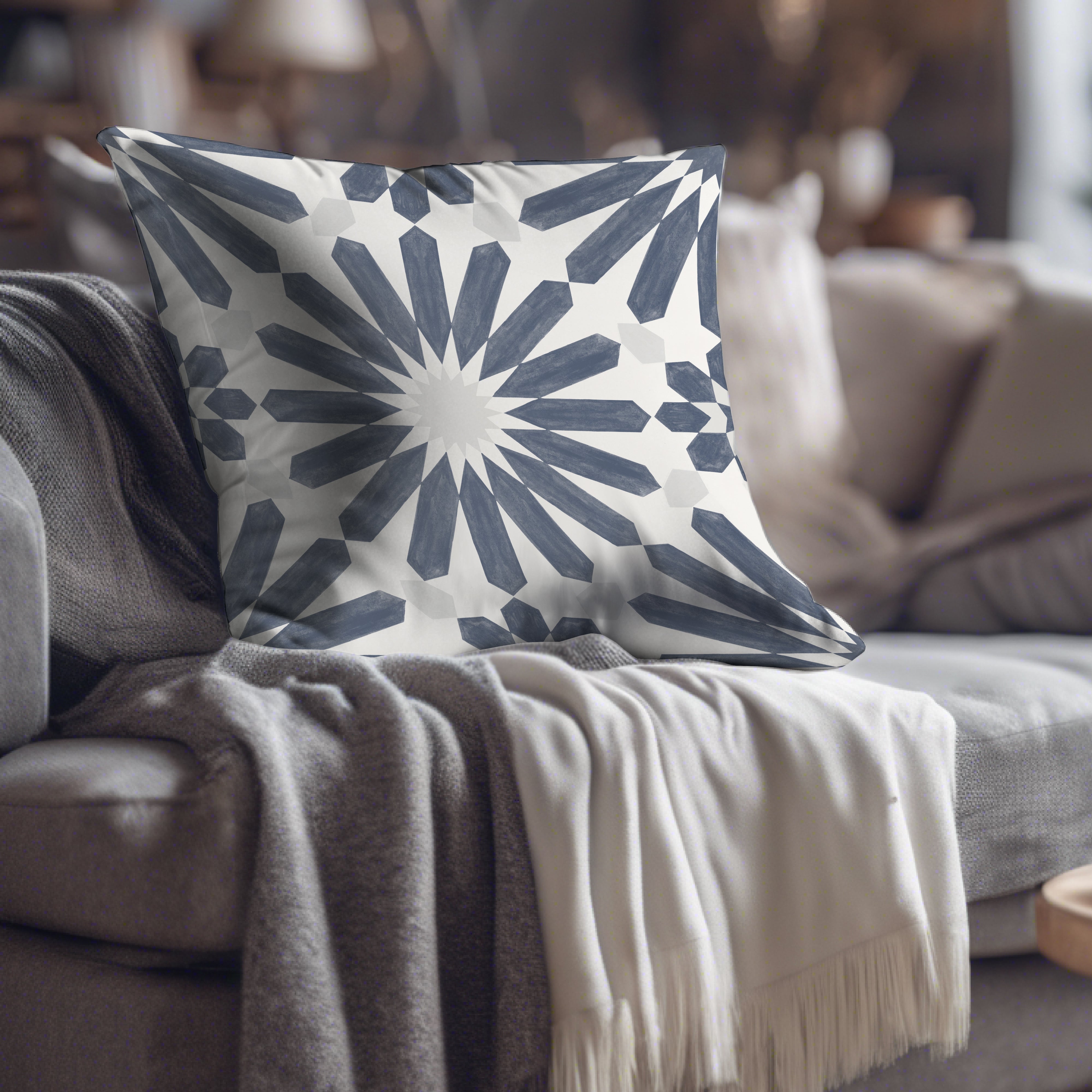 a gray and white pillow sitting on top of a couch