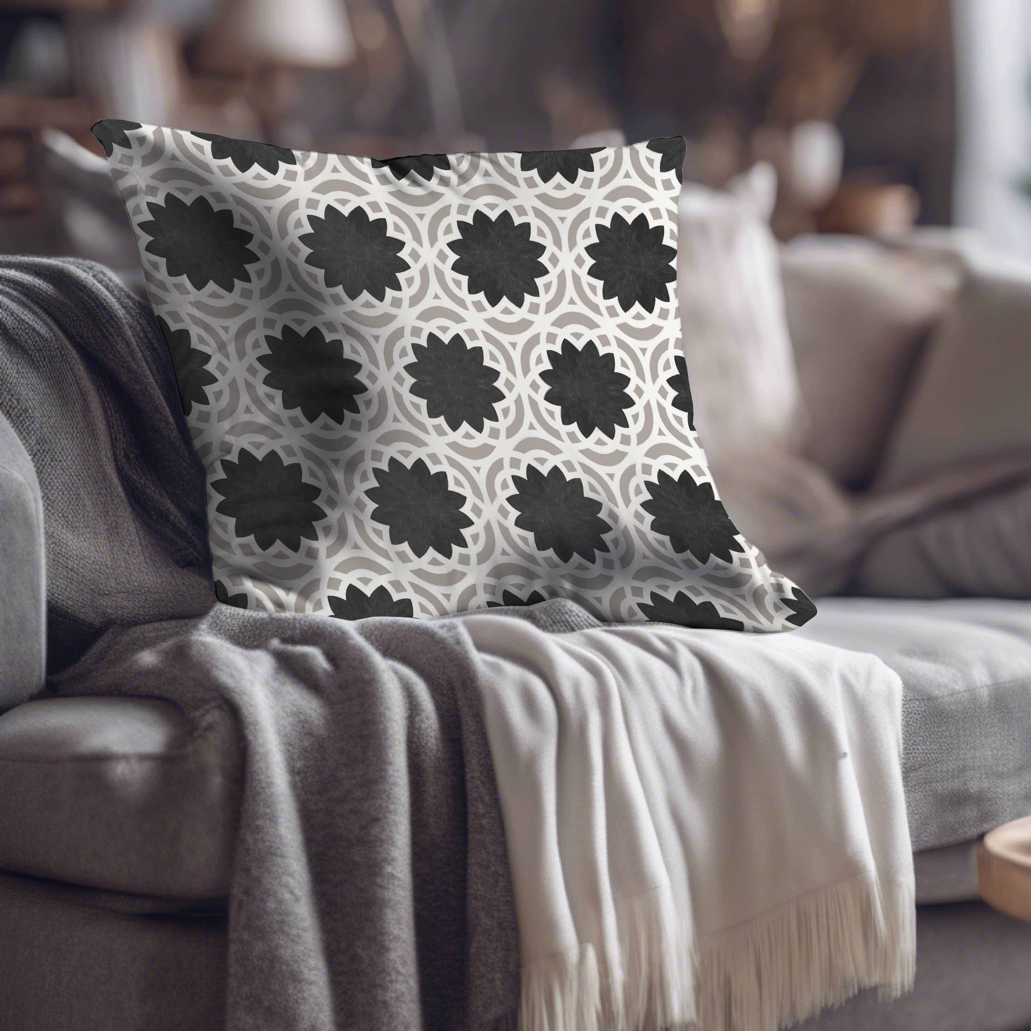 a black and white pillow sitting on top of a couch