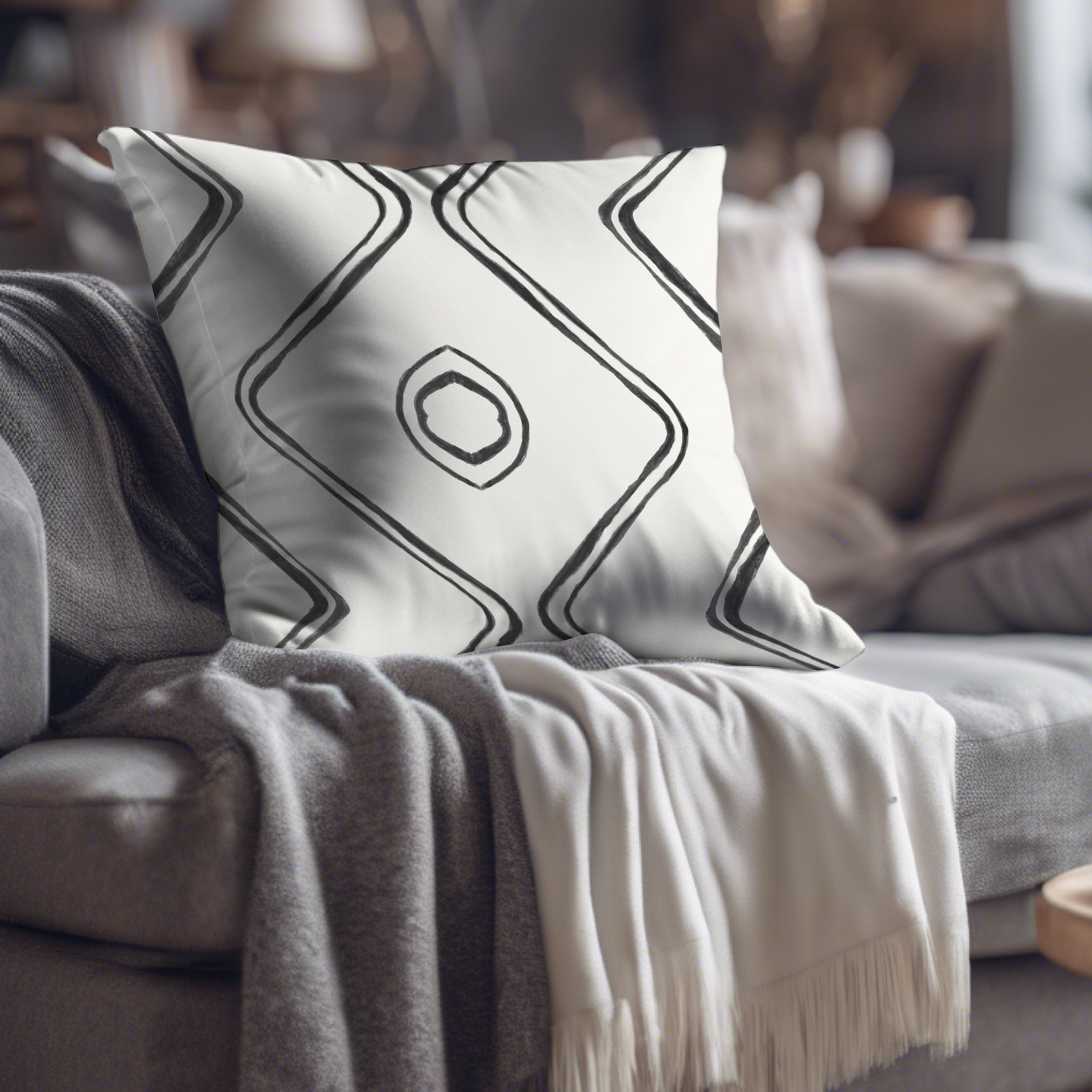 a white and black pillow sitting on top of a couch