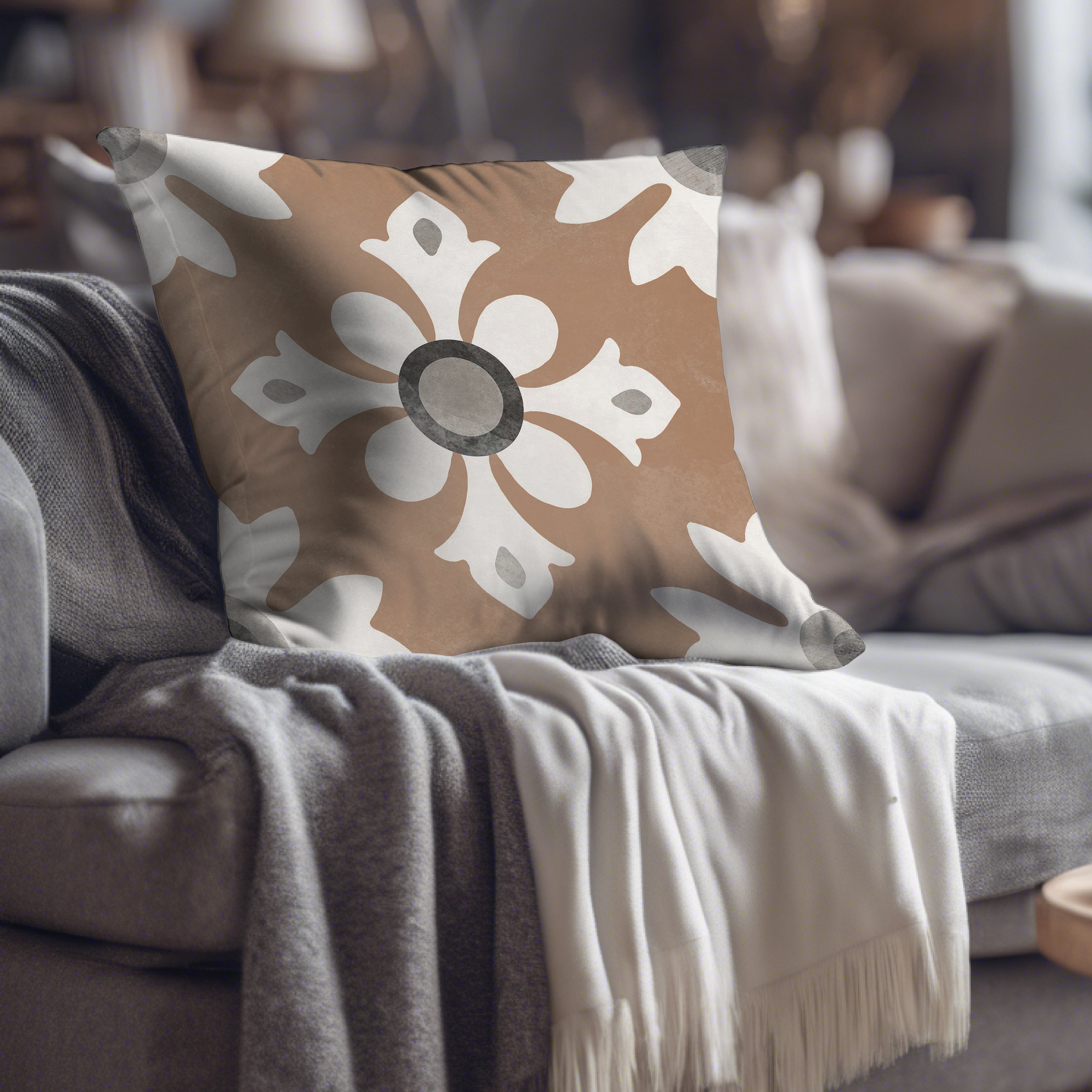 a brown and white pillow sitting on top of a couch
